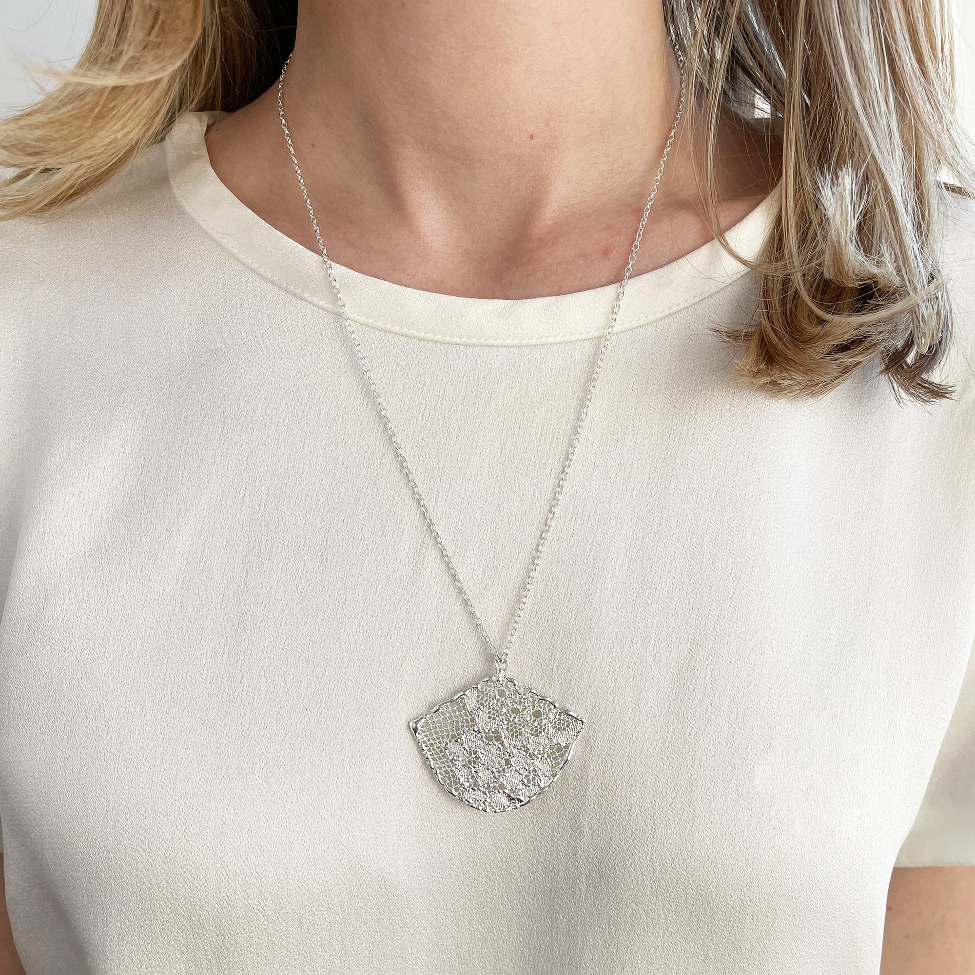 Fan shaped lace necklace in sterling silver.