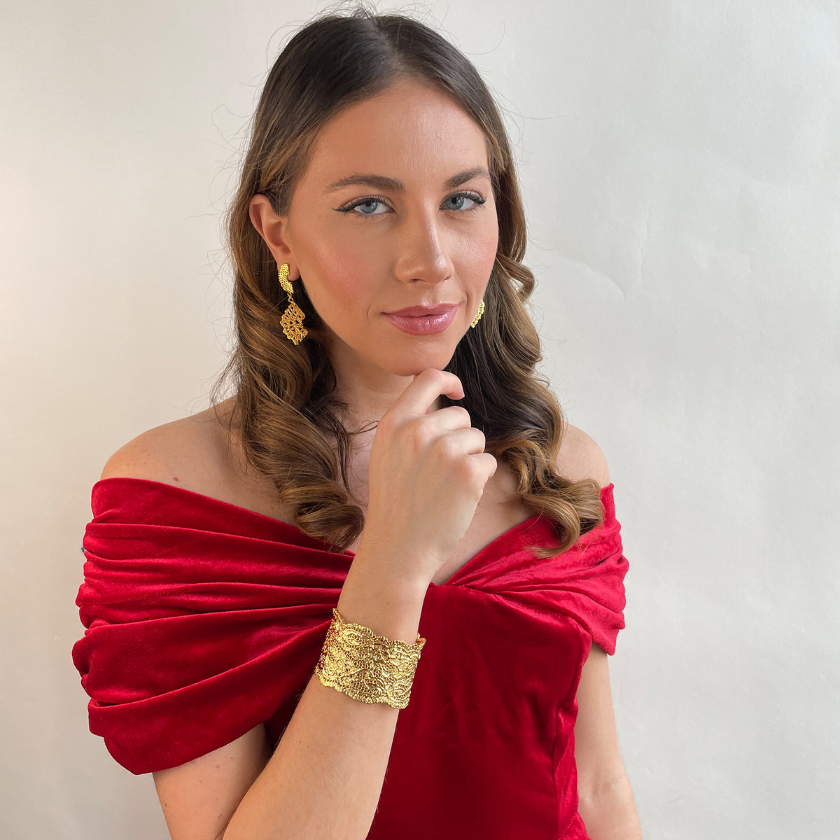 Lace cuff bracelet made from antique double scalloped lace dipped in 24k gold worn by a model.