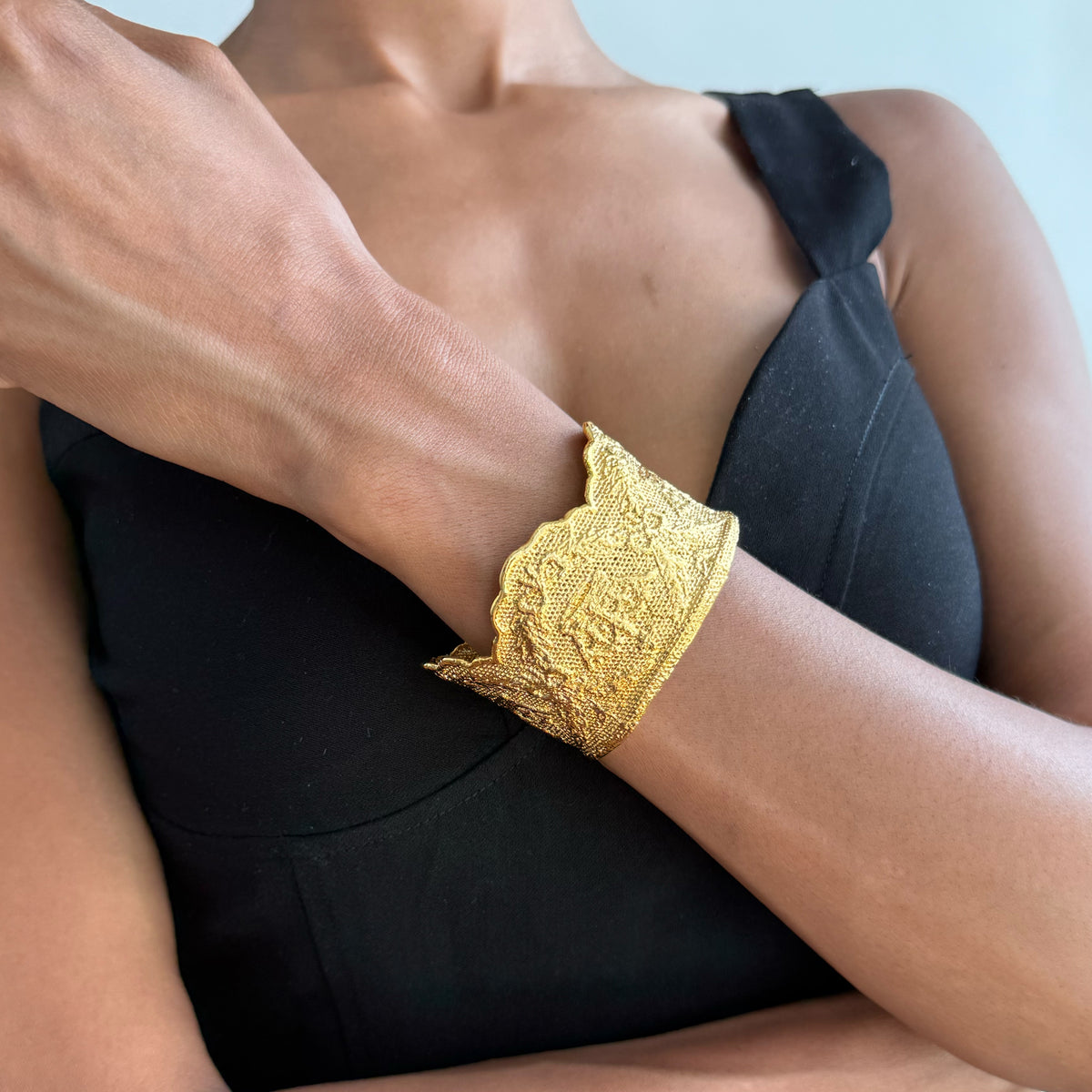 Model wearing lace cuff bracelet Margaret Rose in 24k gold made with British royal lace.