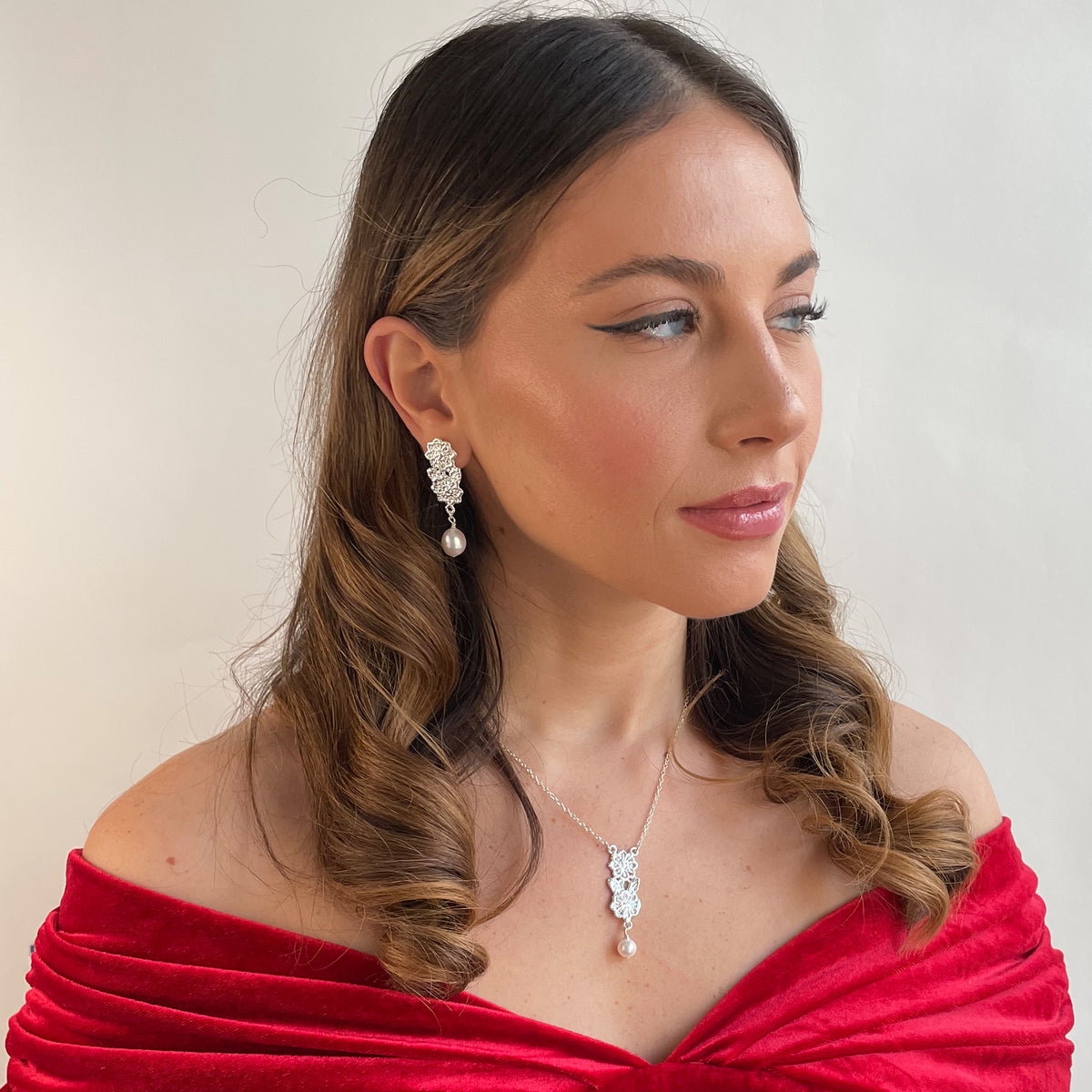 Model wearing baroque pearl earrings with lace garland and matching necklace in sterling silver.
