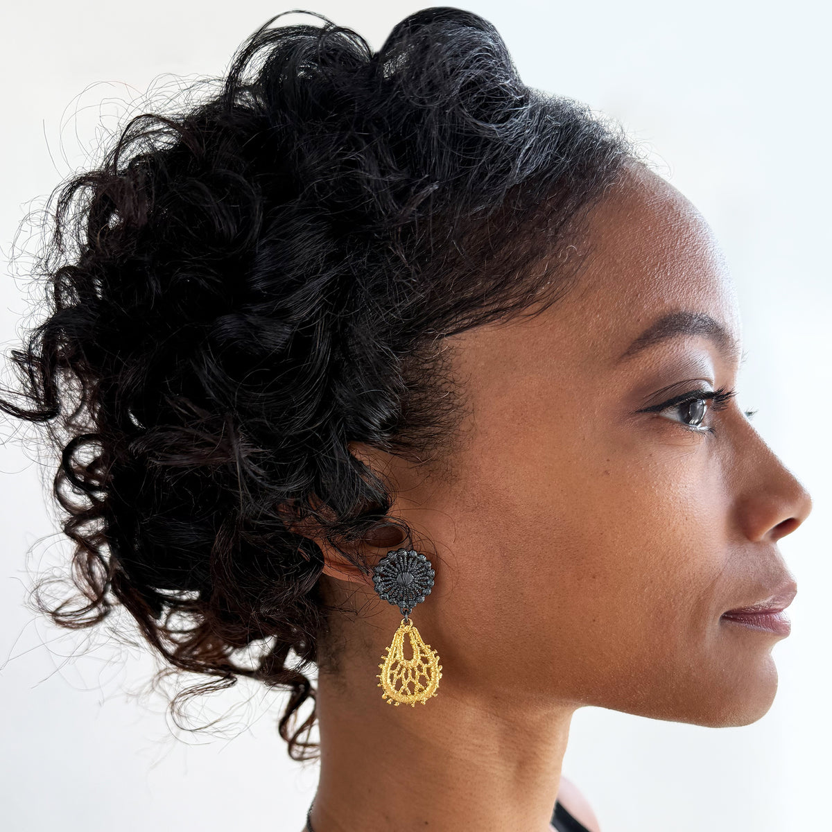 Model wearing the Flora lace earrings in 24k gold and oxidized black sterling silver.