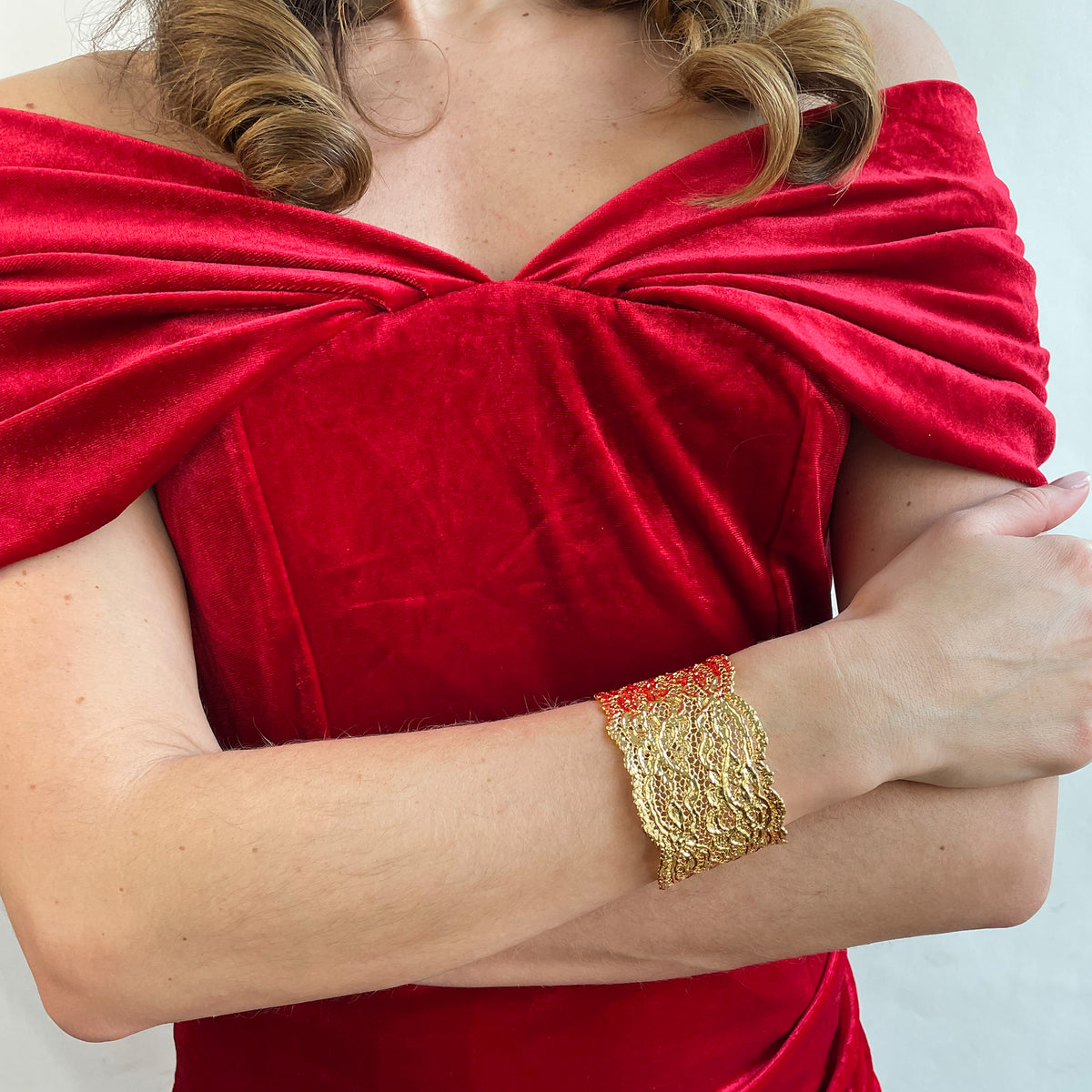 Lace cuff bracelet made from antique double scalloped lace dipped in 24k gold worn by a model.