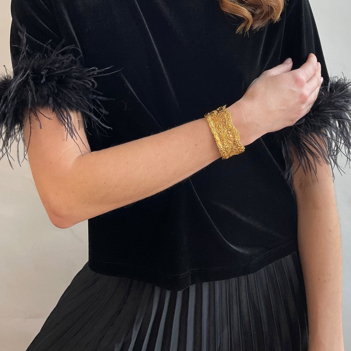 Phyllis fine lace cuff bracelet in dipped 24k gold on a model.