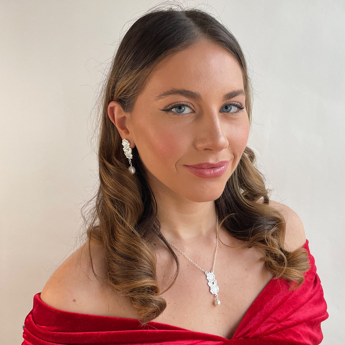 Model wearing baroque pearl earrings with lace garland and matching necklace in sterling silver.