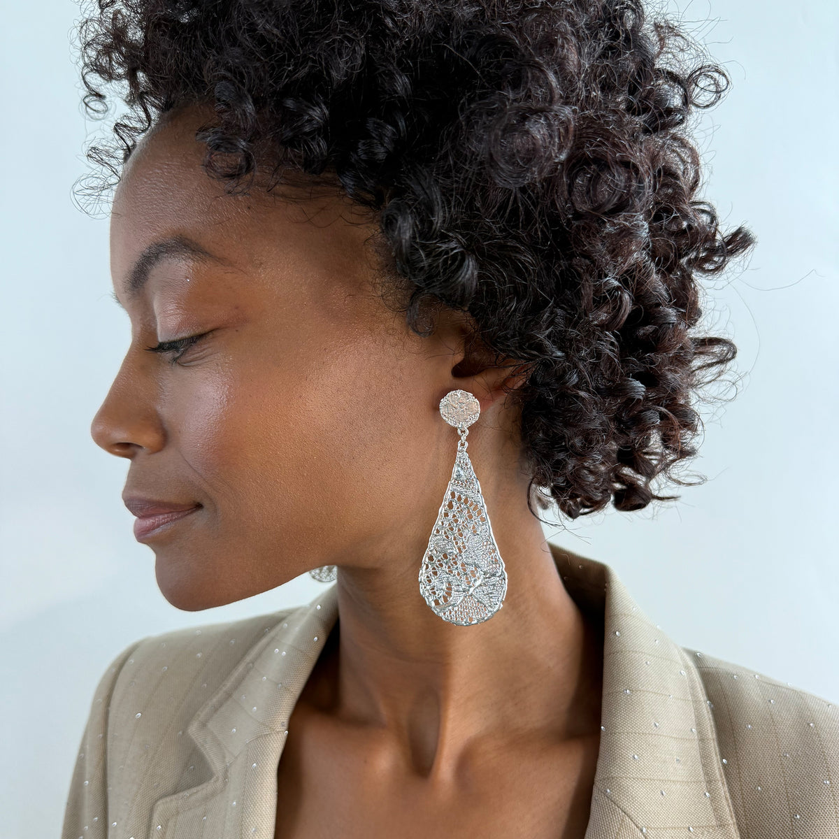 Model wearing lace tear drop earrings dipped in sterling silver, feather light. 