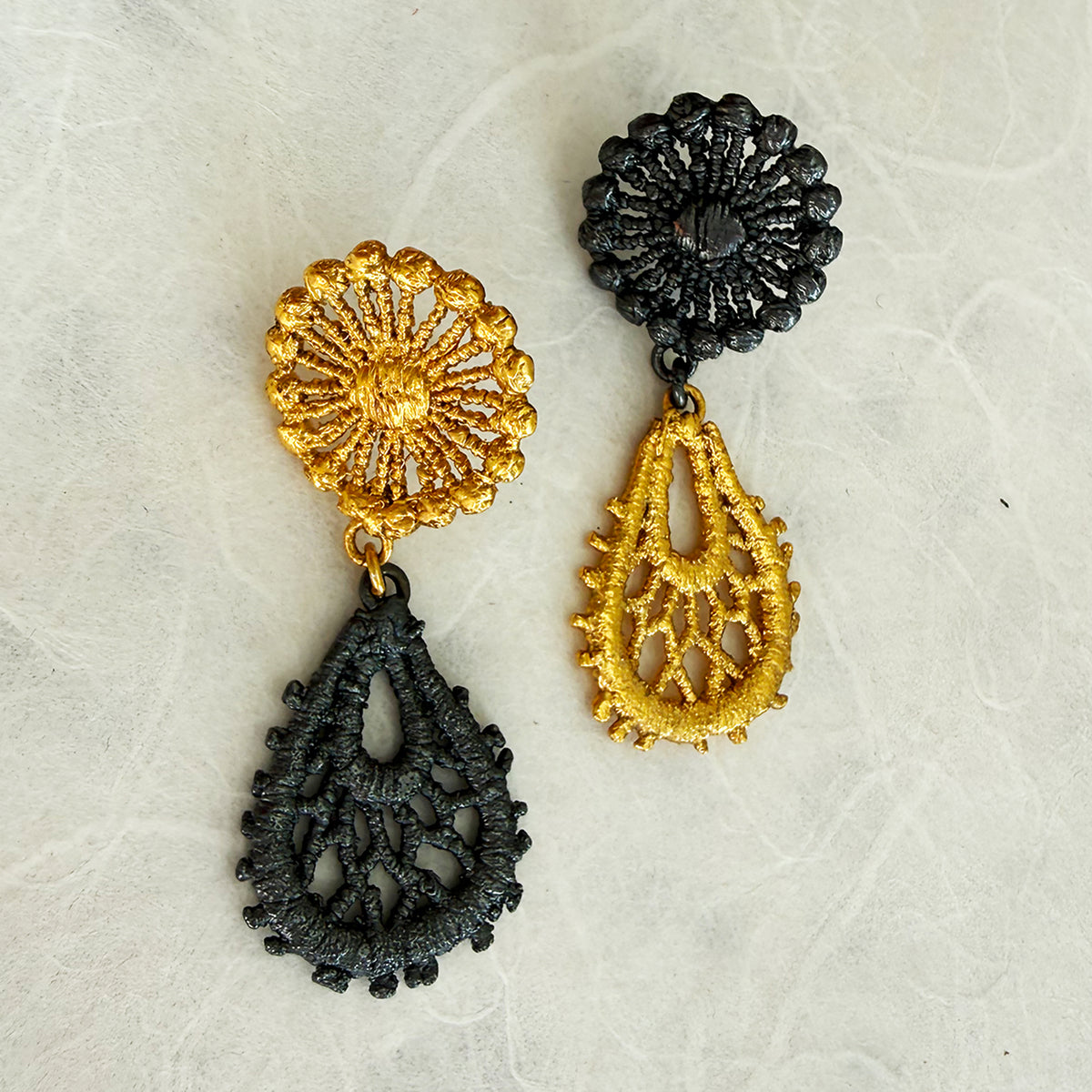 The Flora lace earrings in 24k gold and oxidized black sterling silver.