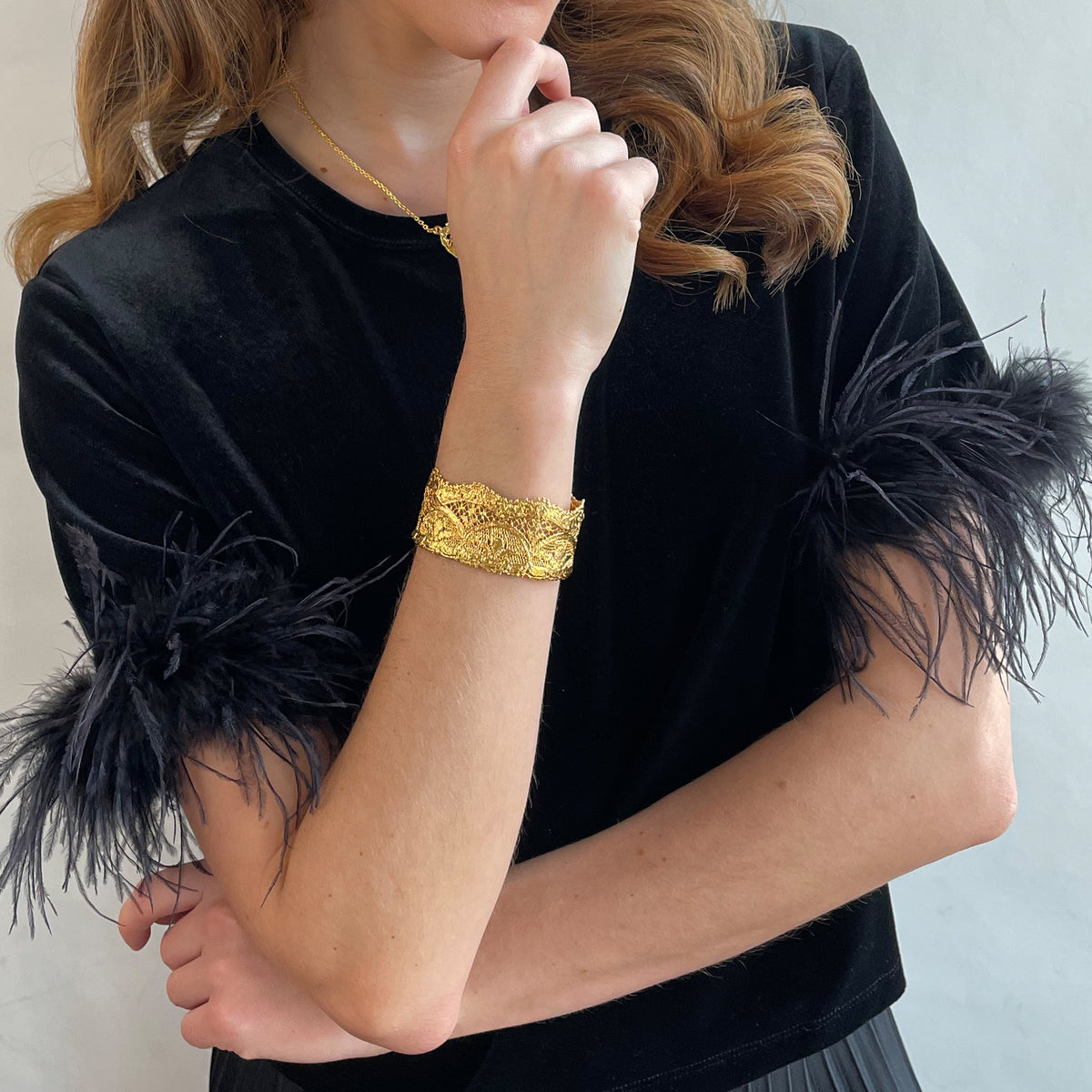 Phyllis fine lace cuff bracelet in dipped 24k gold on a model.