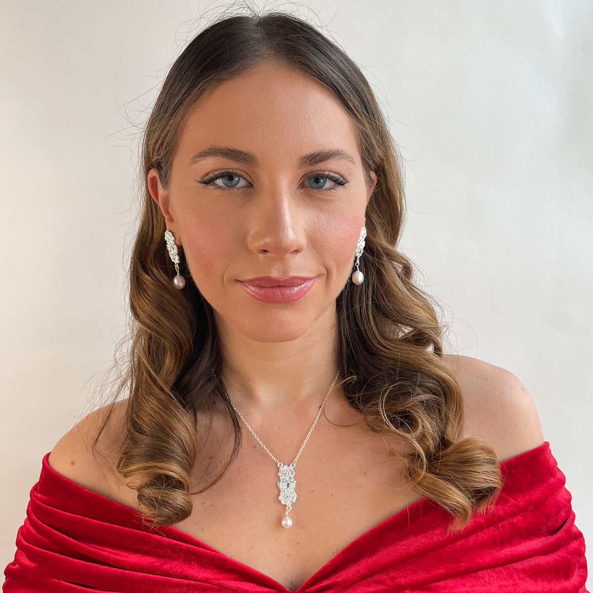 Model wearing baroque pearl earrings with lace garland and matching necklace in sterling silver.