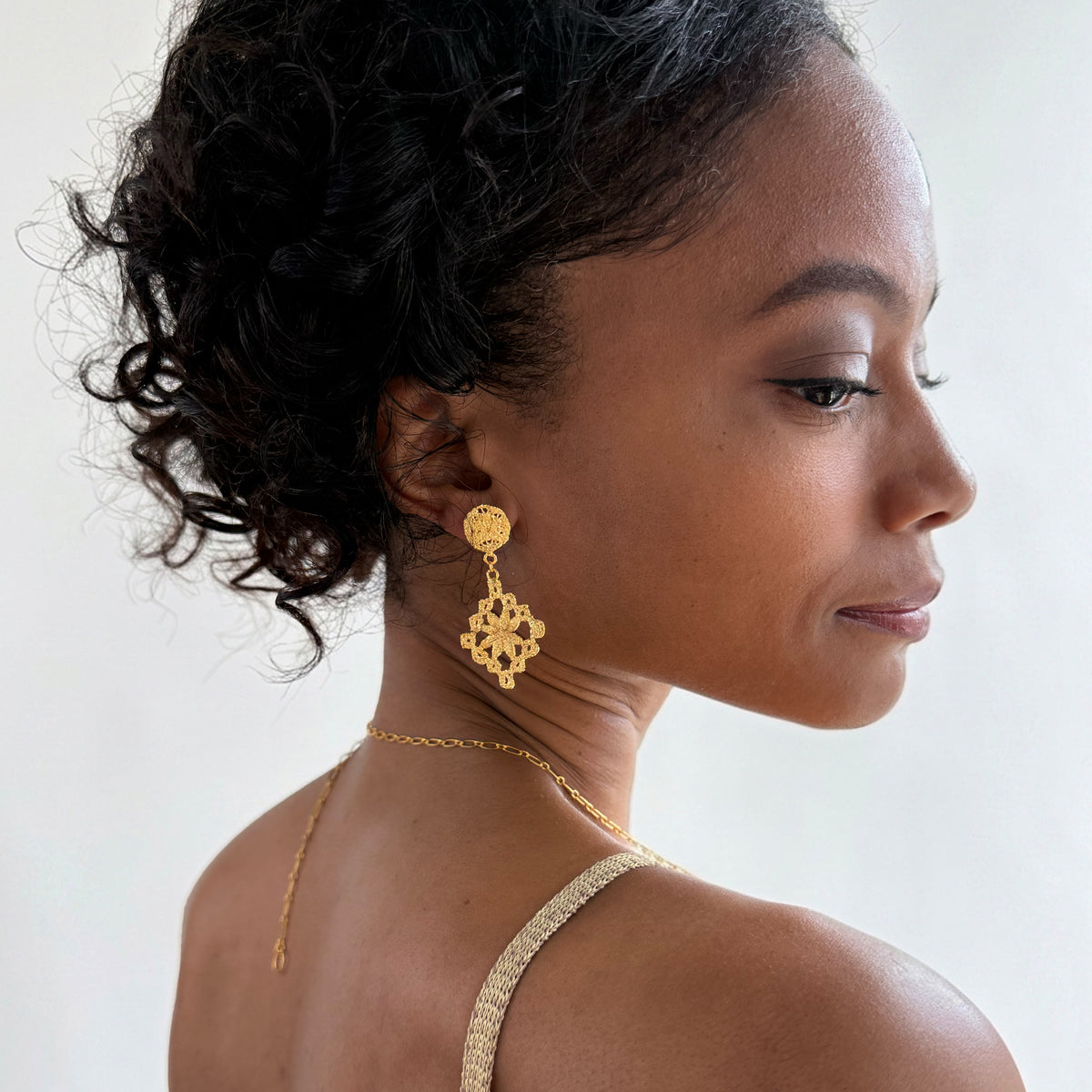 Model wearing chandelier lace earrings in 24k gold.