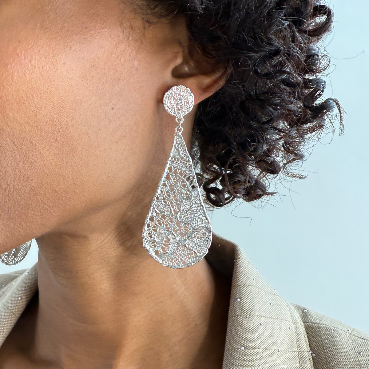 Model wearing lace tear drop earrings dipped in sterling silver, feather light. 