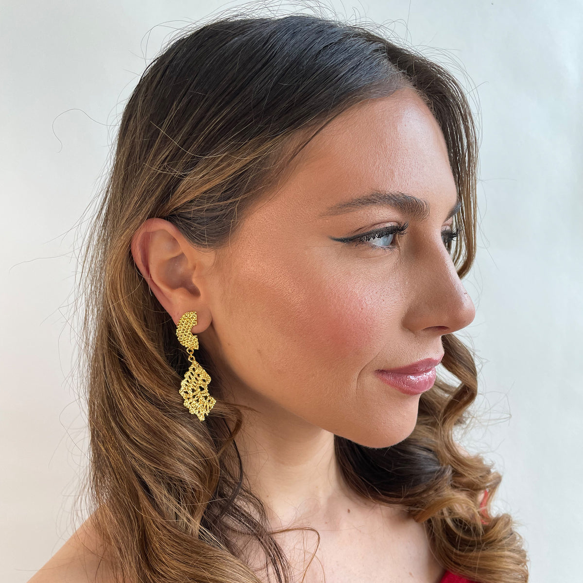Model wearing dangle lace earrings dipped in 24k gold.