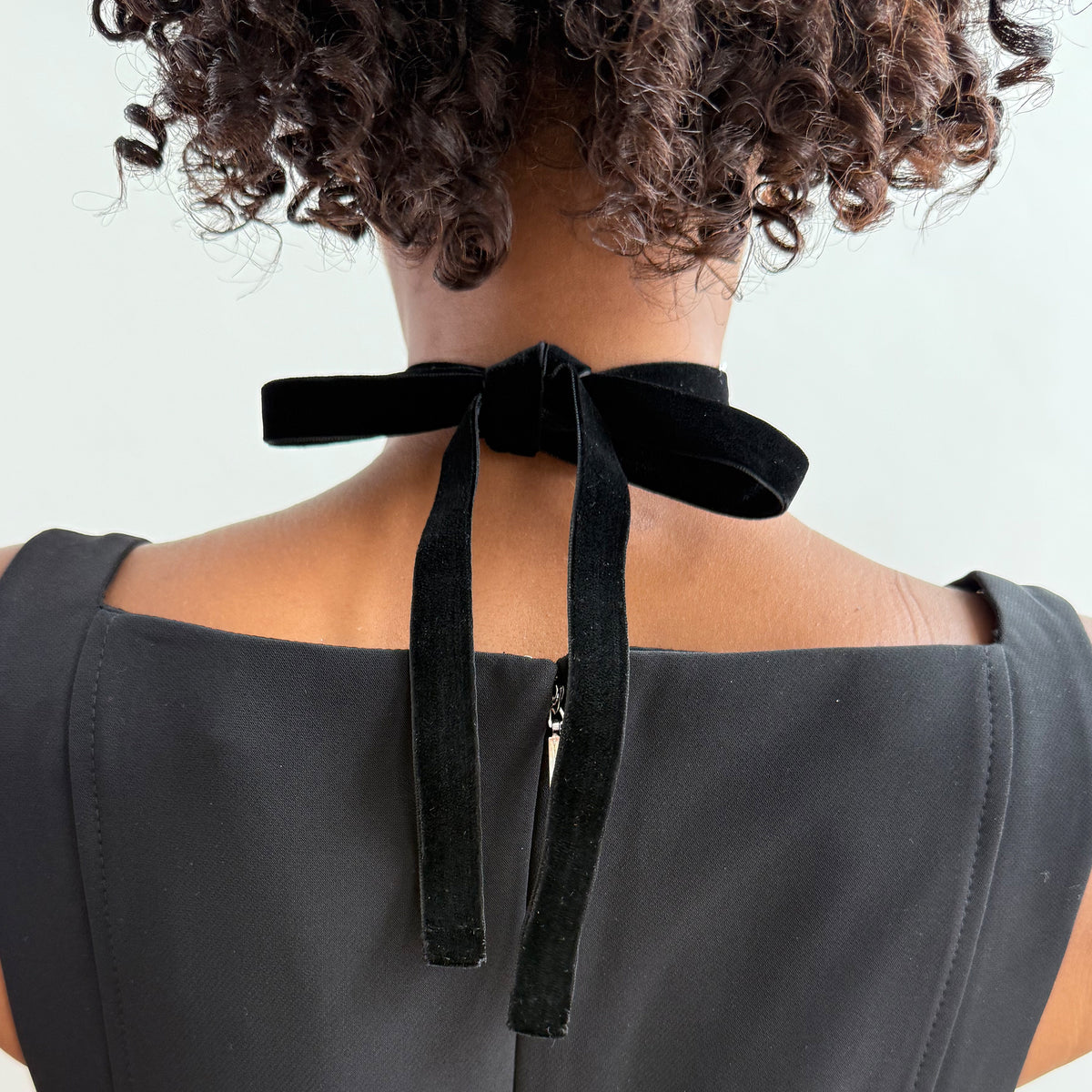 A model showing the back velvet bow of the silver lace choker.