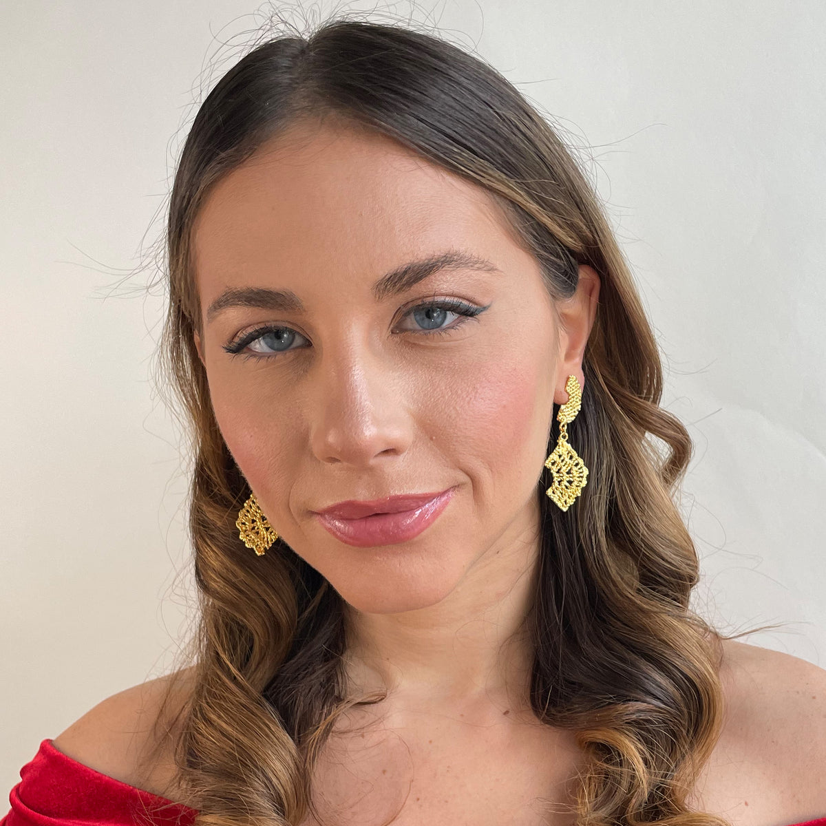 Model wearing dangle lace earrings dipped in 24k gold.