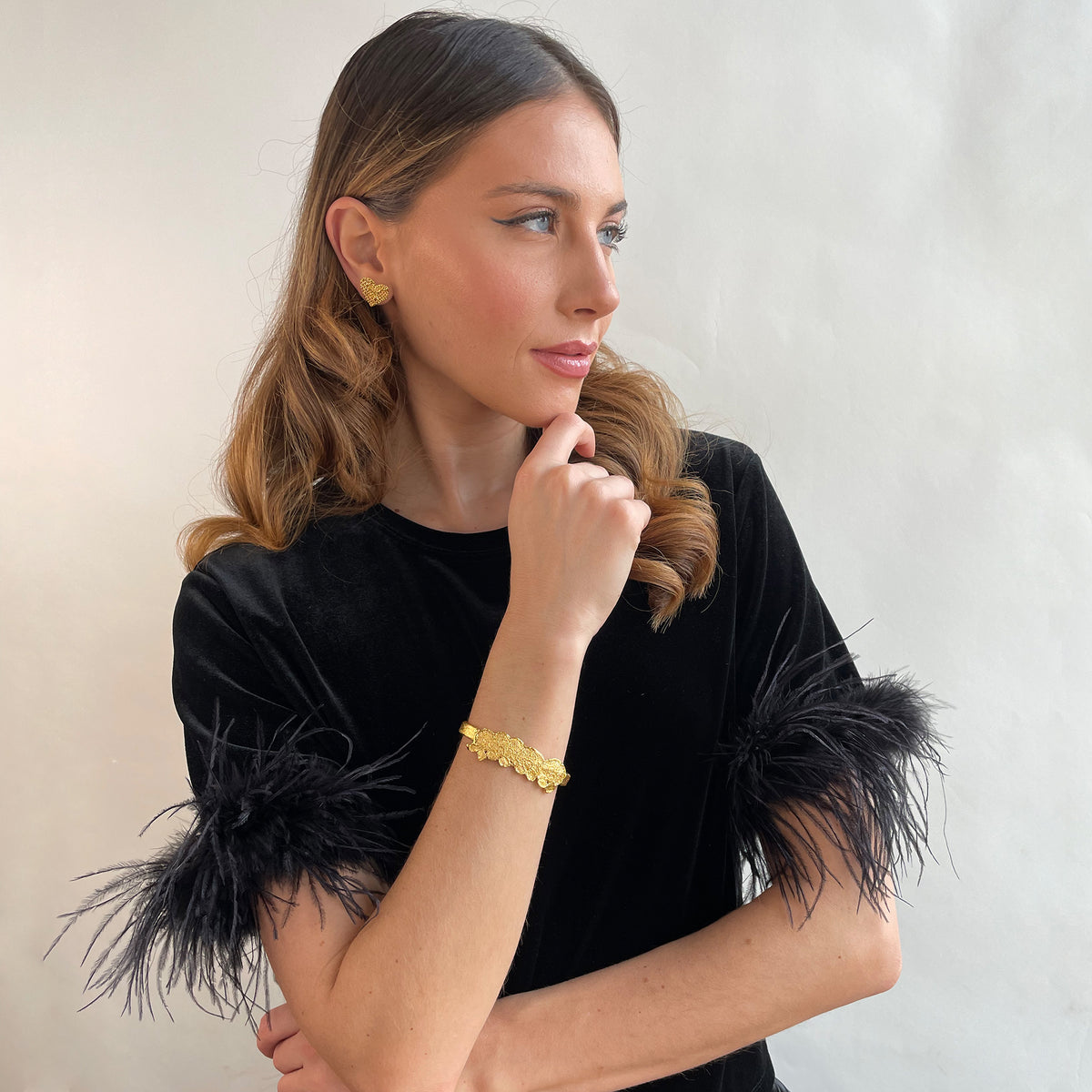 Alex lace bracelet in brilliant 24k gold on a model.