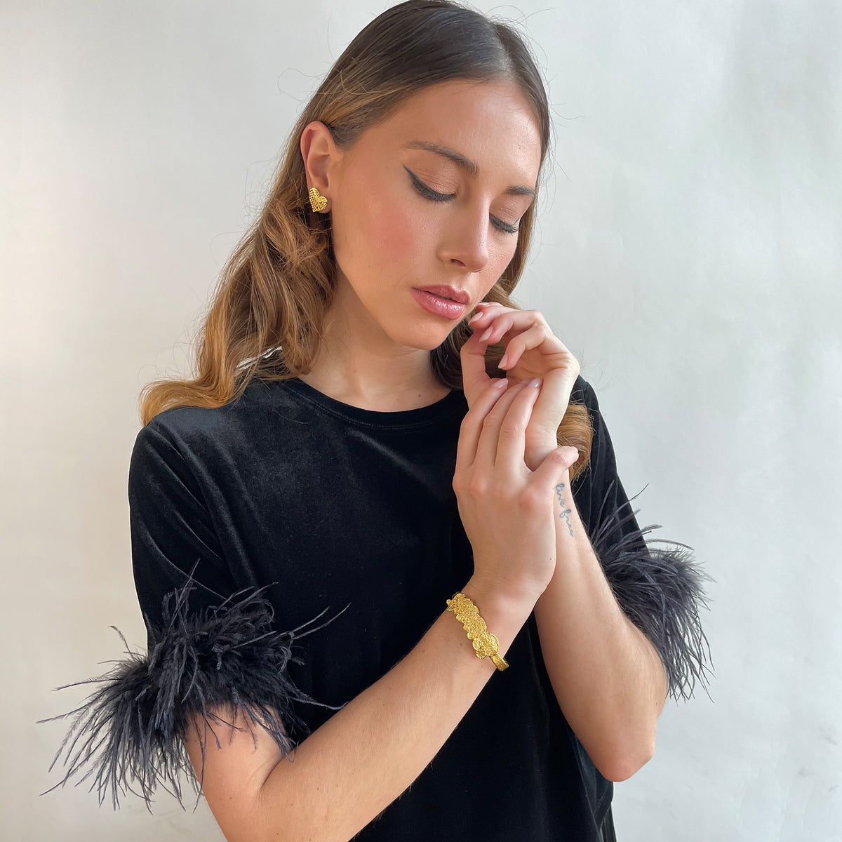 Alex lace bracelet in brilliant 24k gold on a model.