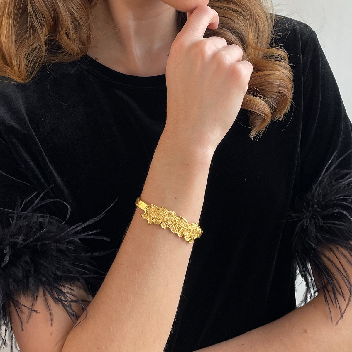 Alex lace bracelet in brilliant 24k gold on a model.