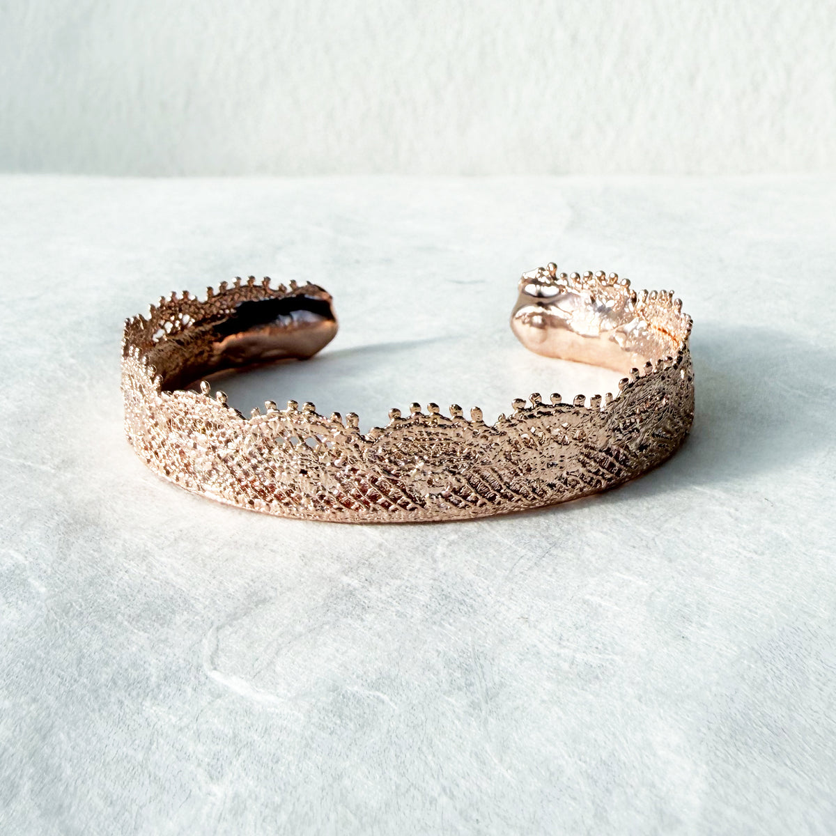 Lace bangle bracelet in dipped rose gold. Signed and numbered in the back.