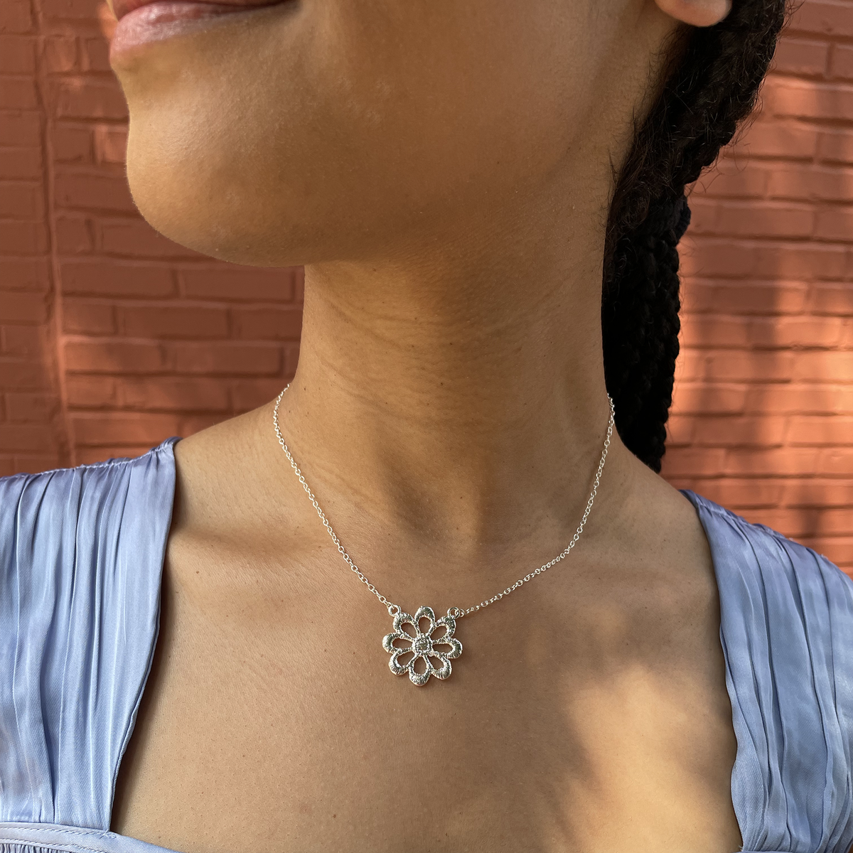 Lace flower necklace in sterling silver worn by a model.