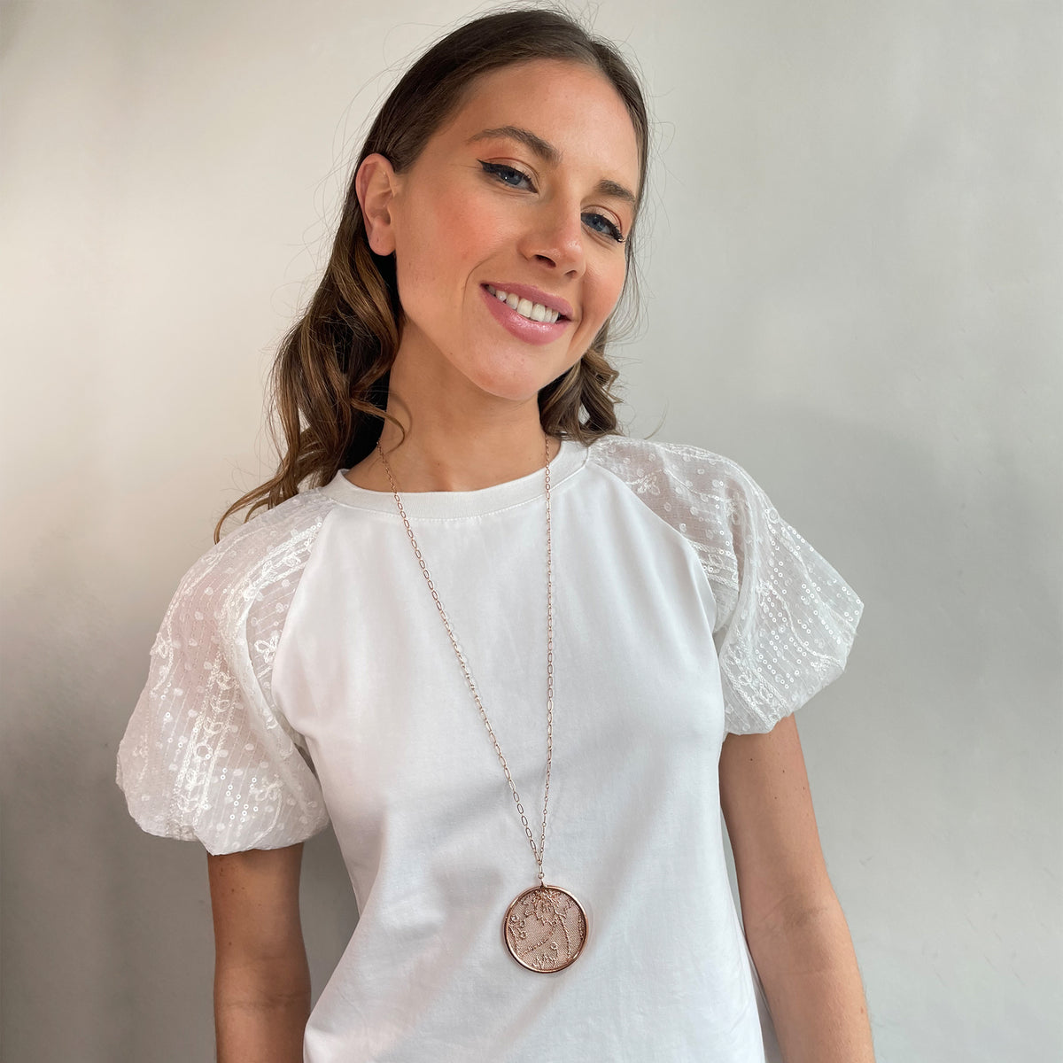 Cecilia circular lace pendant necklace in rose gold worn by a model.