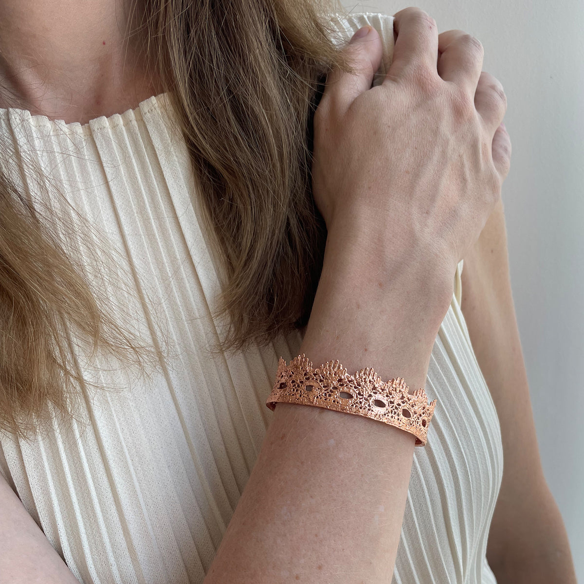 Chiara Fine lace cuff bracelet dipped in Rose gold on a model.