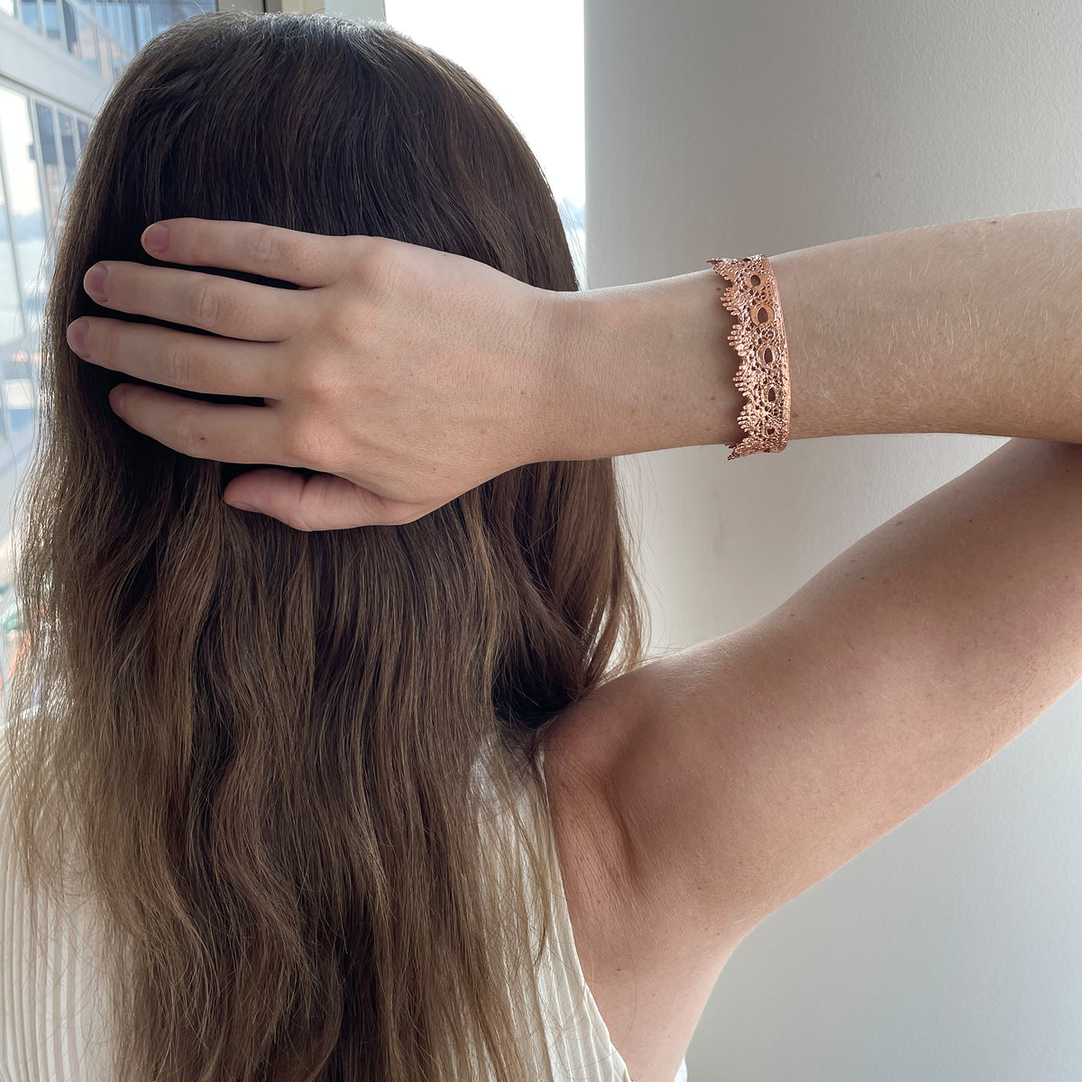 Chiara Fine lace cuff bracelet dipped in Rose gold on a model.