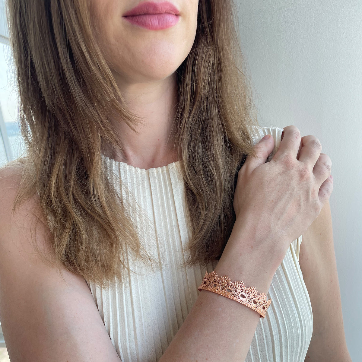 Chiara Fine lace cuff bracelet dipped in Rose gold on a model.