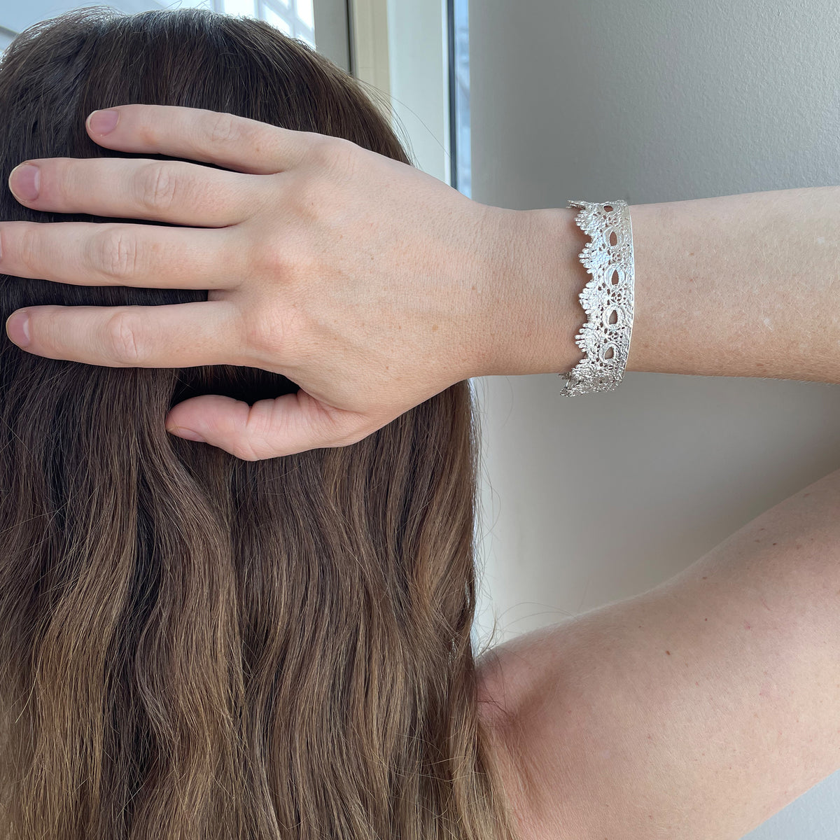 Chiara Fine lace cuff bracelet dipped in Sterling silver on a model.