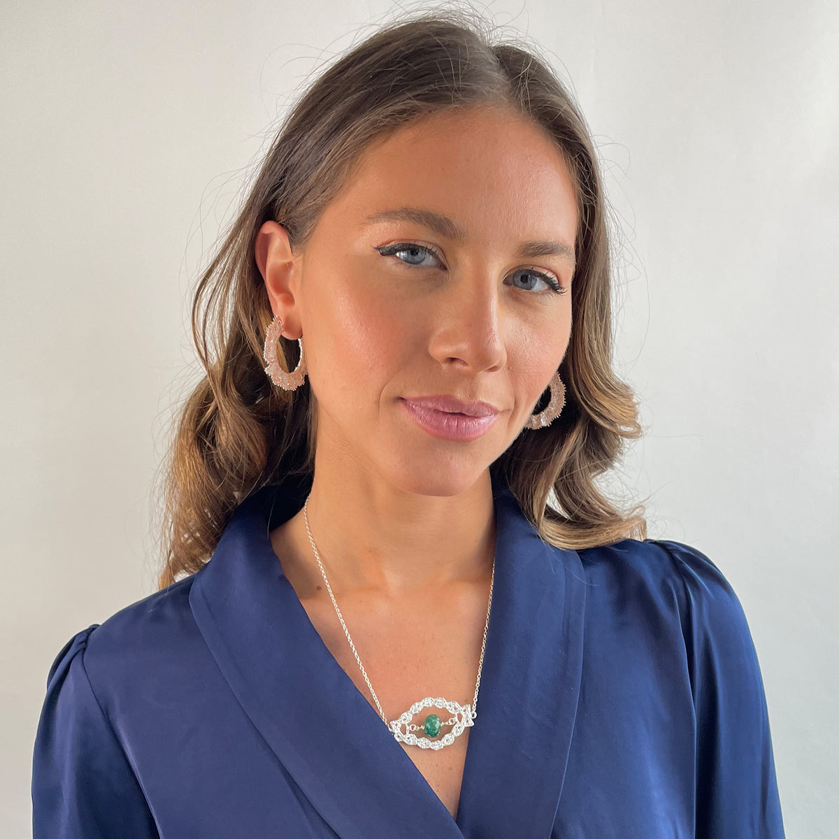 Chloé silver lace pendant with an Emerald centerpiece on a model.