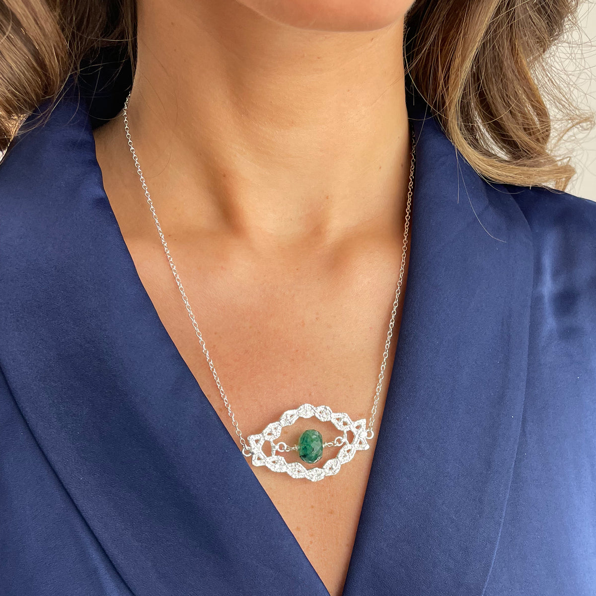 Chloé silver lace pendant with an Emerald centerpiece on a model.