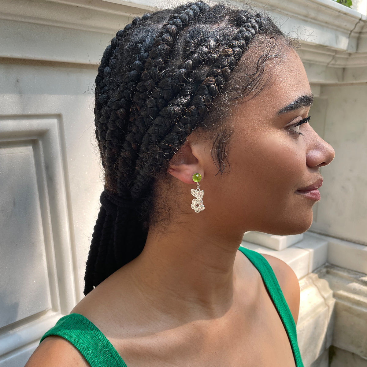 Peridot earrings with lace flowers in sterling silver worn by a model.