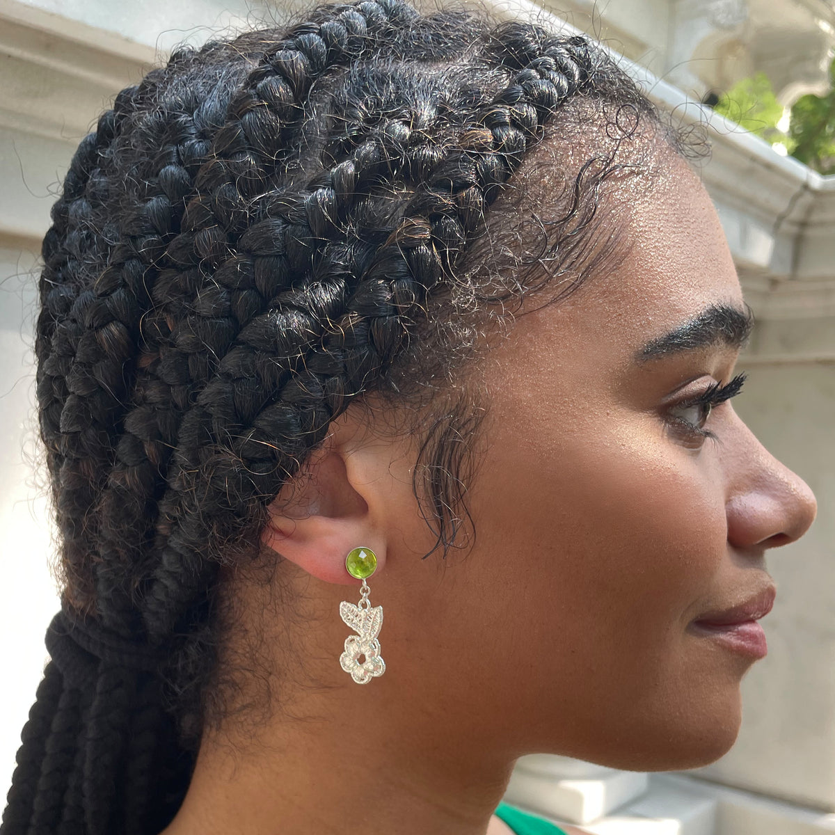 Peridot earrings with lace flowers in sterling silver worn by a model.