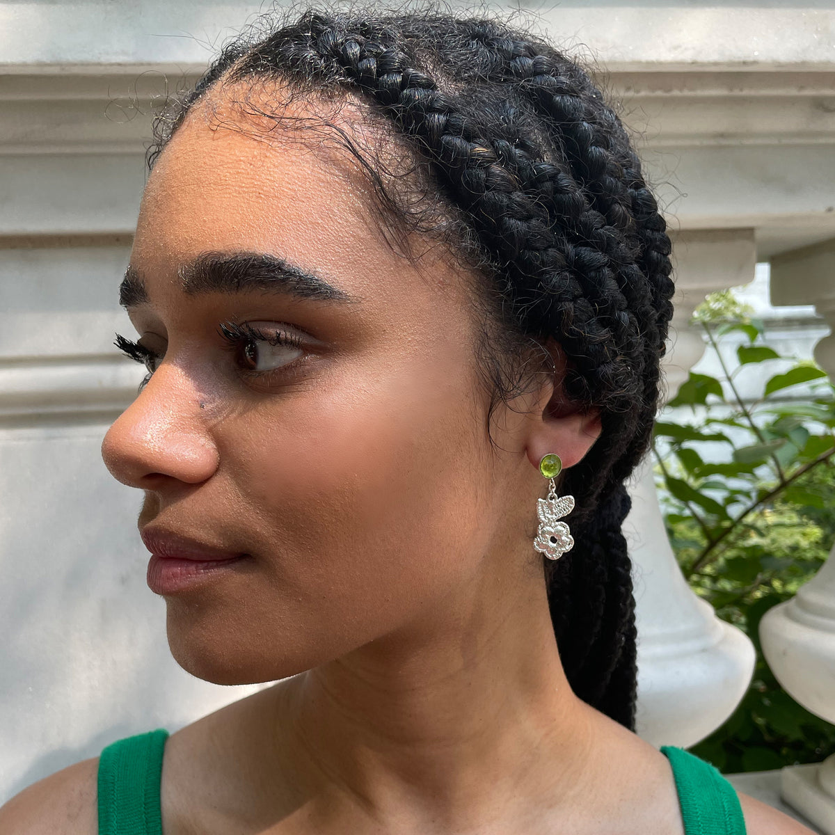 Peridot earrings with lace flowers in sterling silver worn by a model.