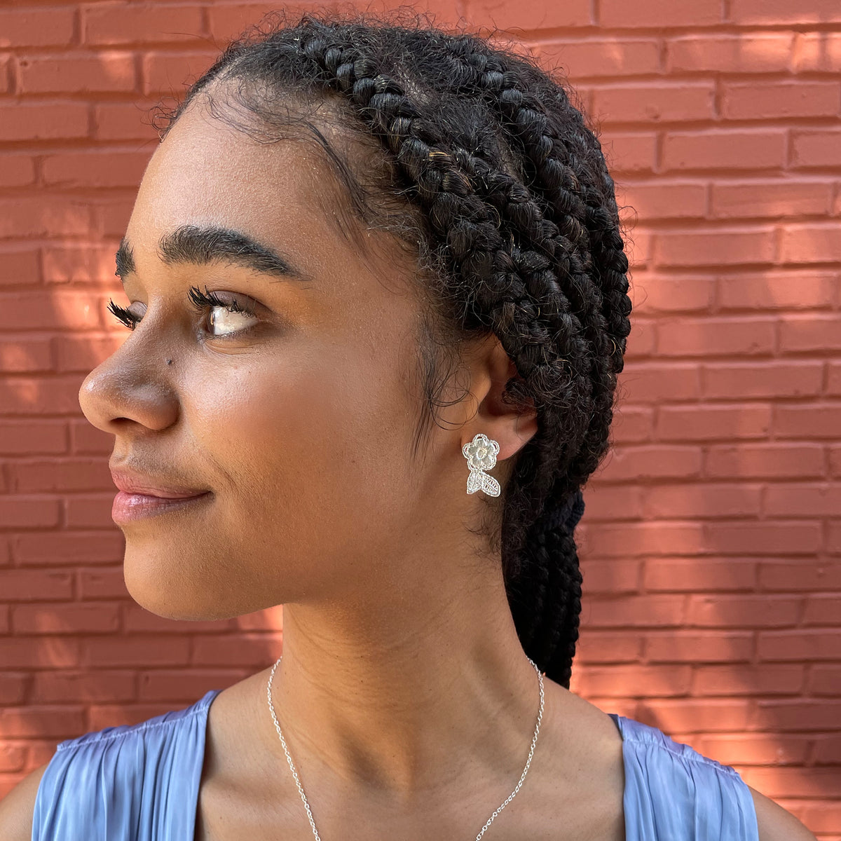 Flower lace stud earrings in sterling silver worn by a model.