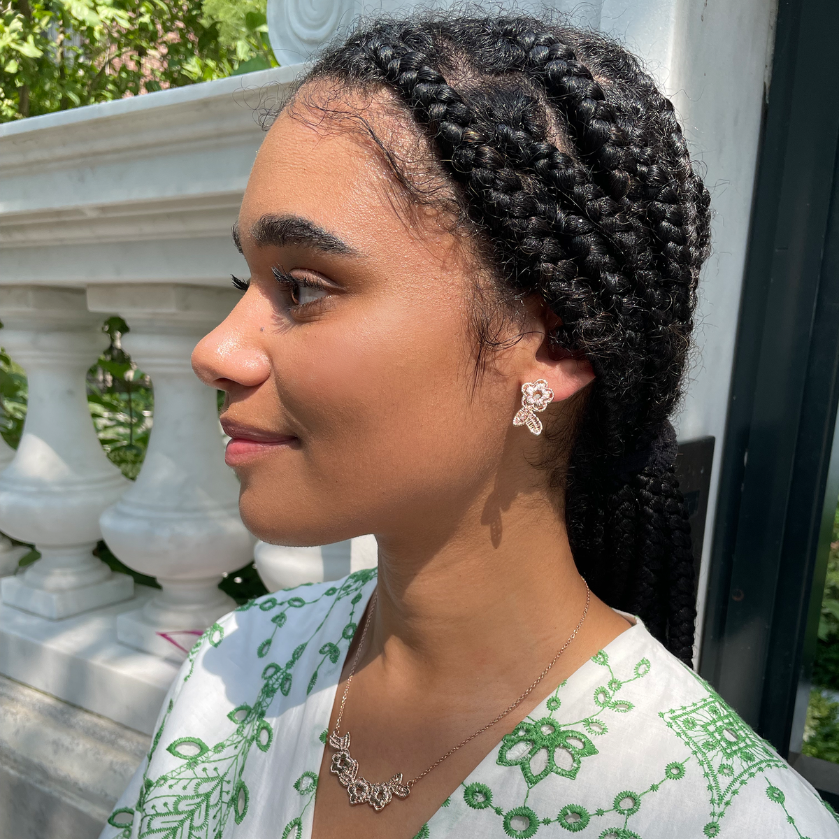 Ella lace earrings and Ellinor lace necklace in rose gold on a model.