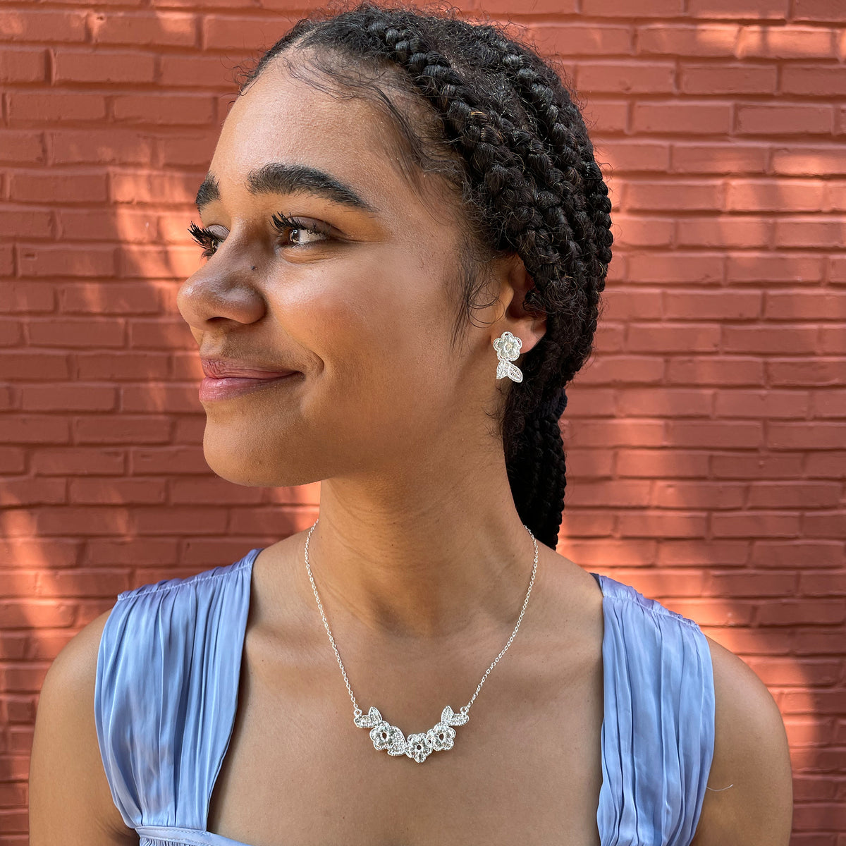 Lace flower garland necklace in sterling silver worn by a model.