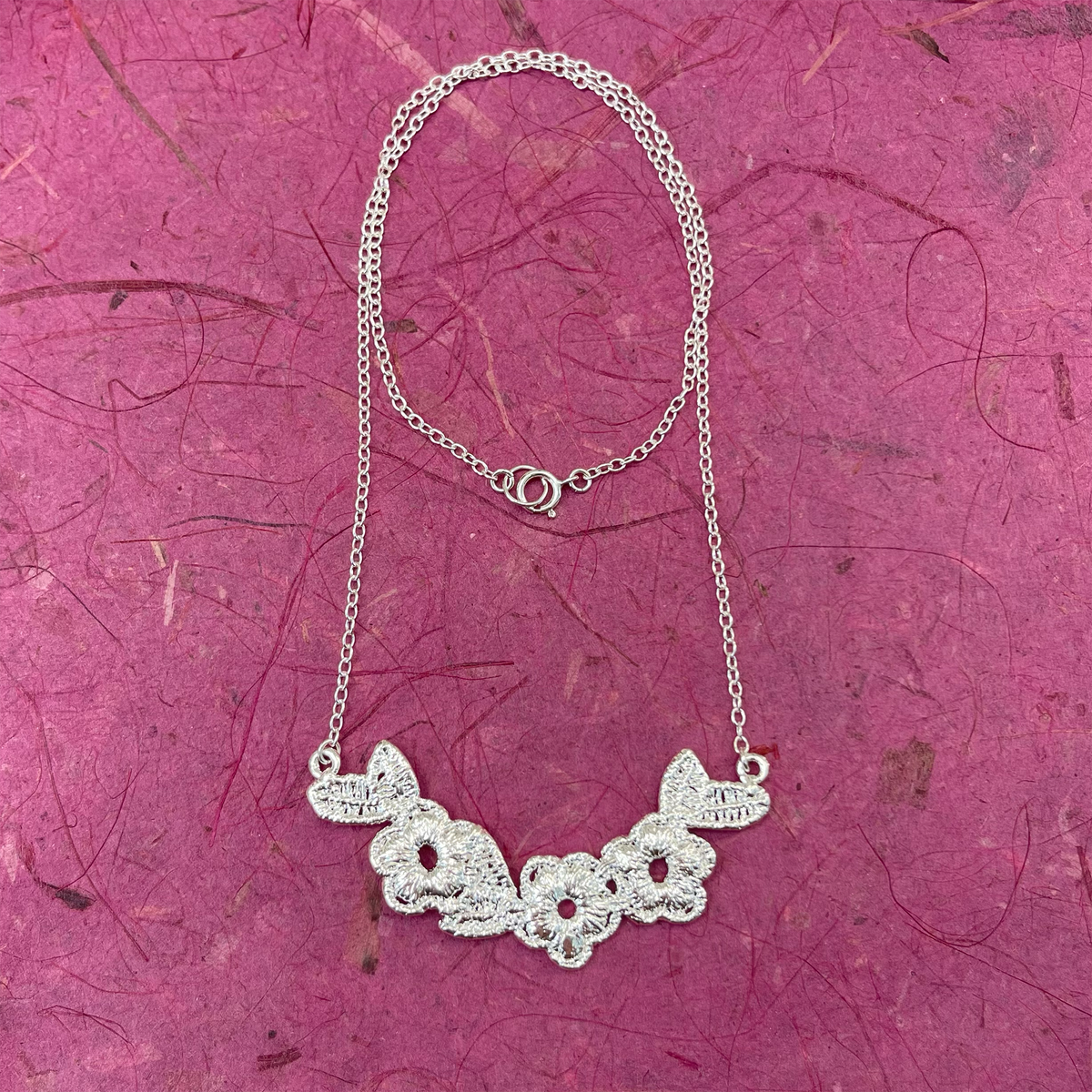 Lace flower garland necklace in sterling silver.