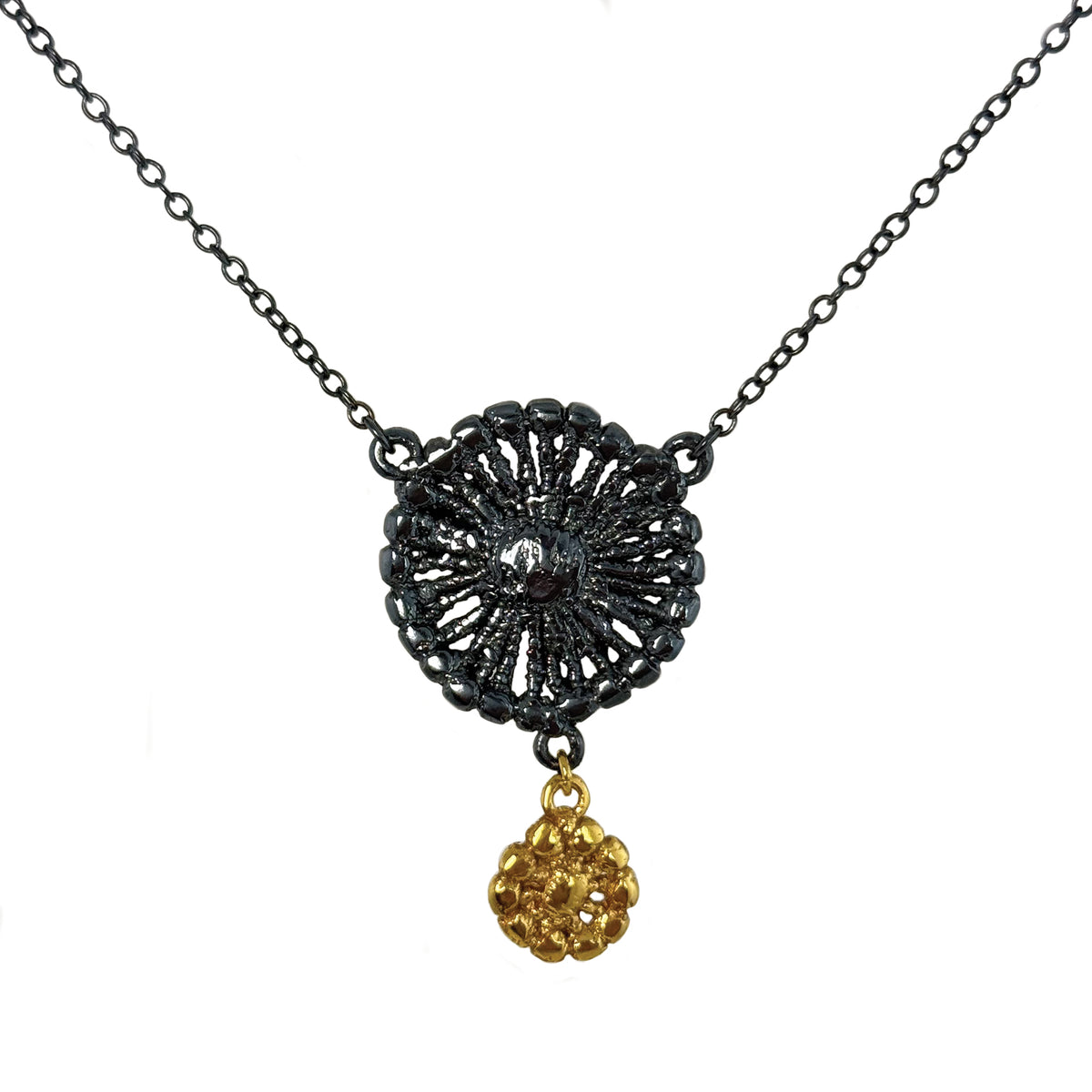 Necklace with black oxidized flower silver pendant and 24k gold charm.