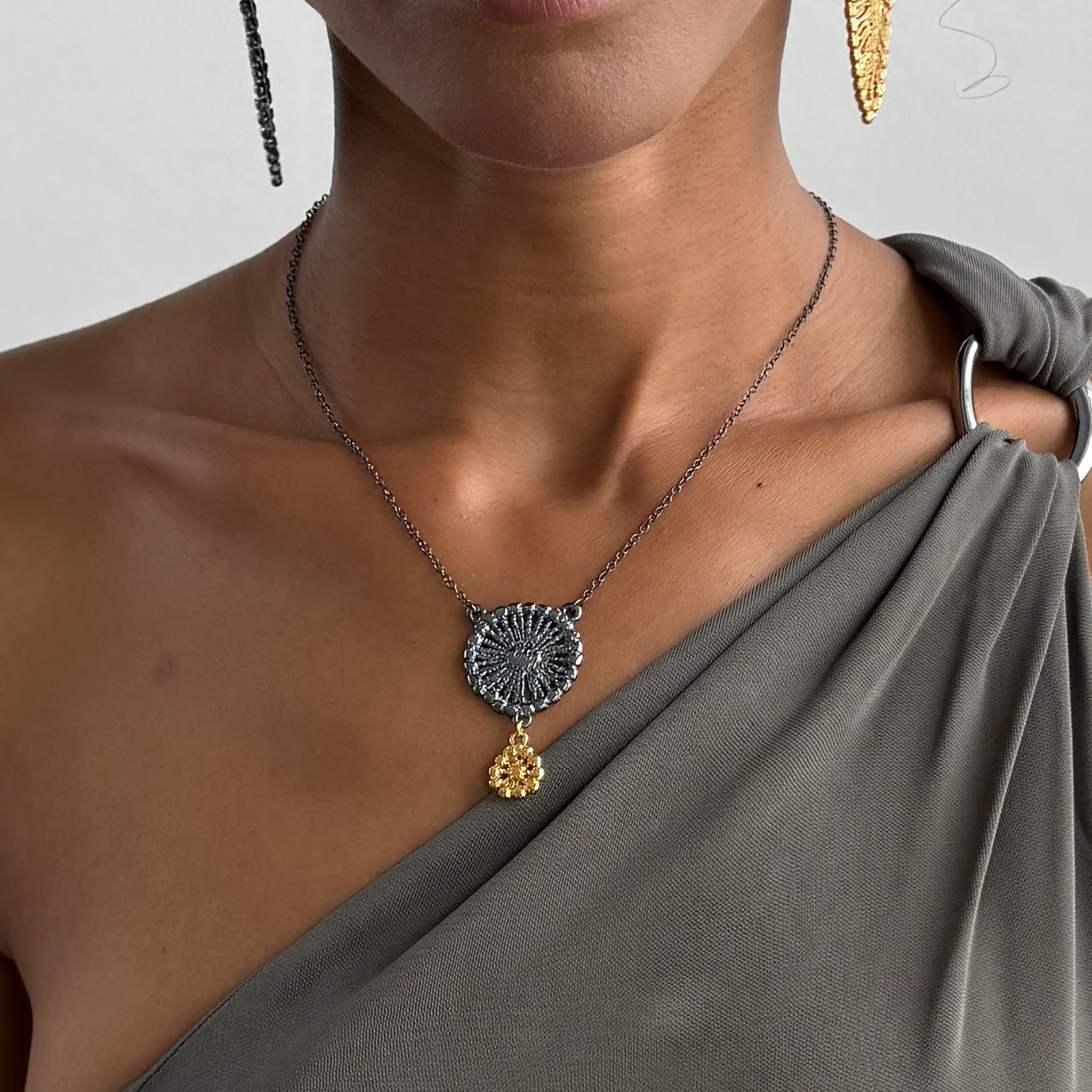 Necklace with black oxidized flower silver pendant and 24k gold charm.