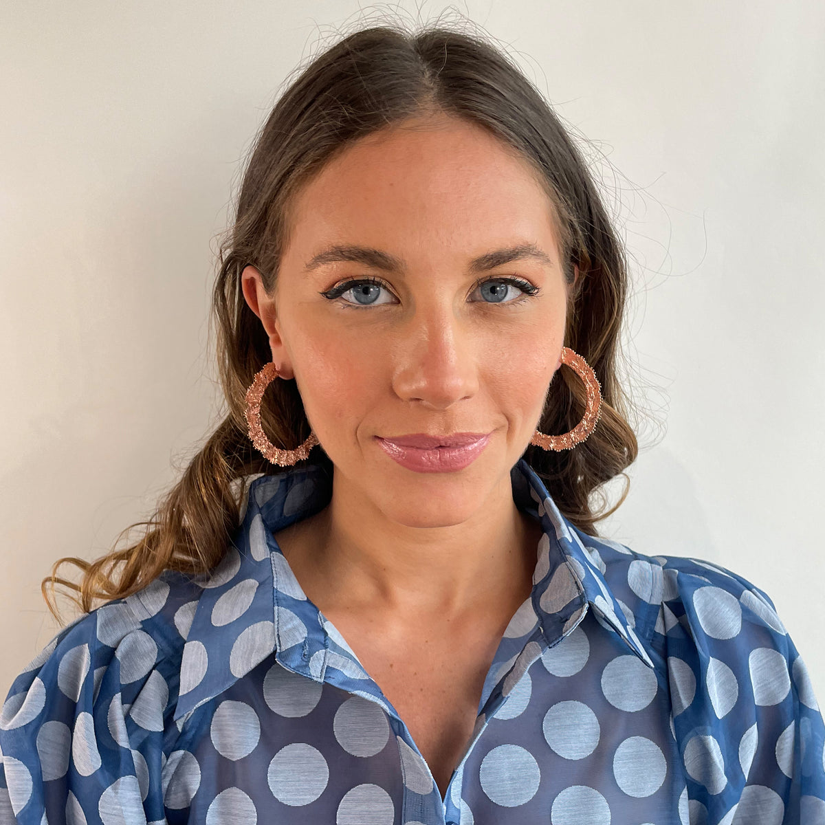 Jacqueline large lace hoop earrings in rose gold on a model.