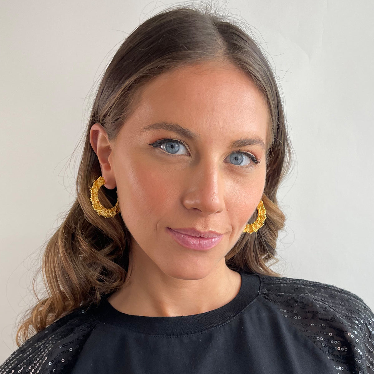 Jeanne lace hoop earrings small in 24k gold on a model.