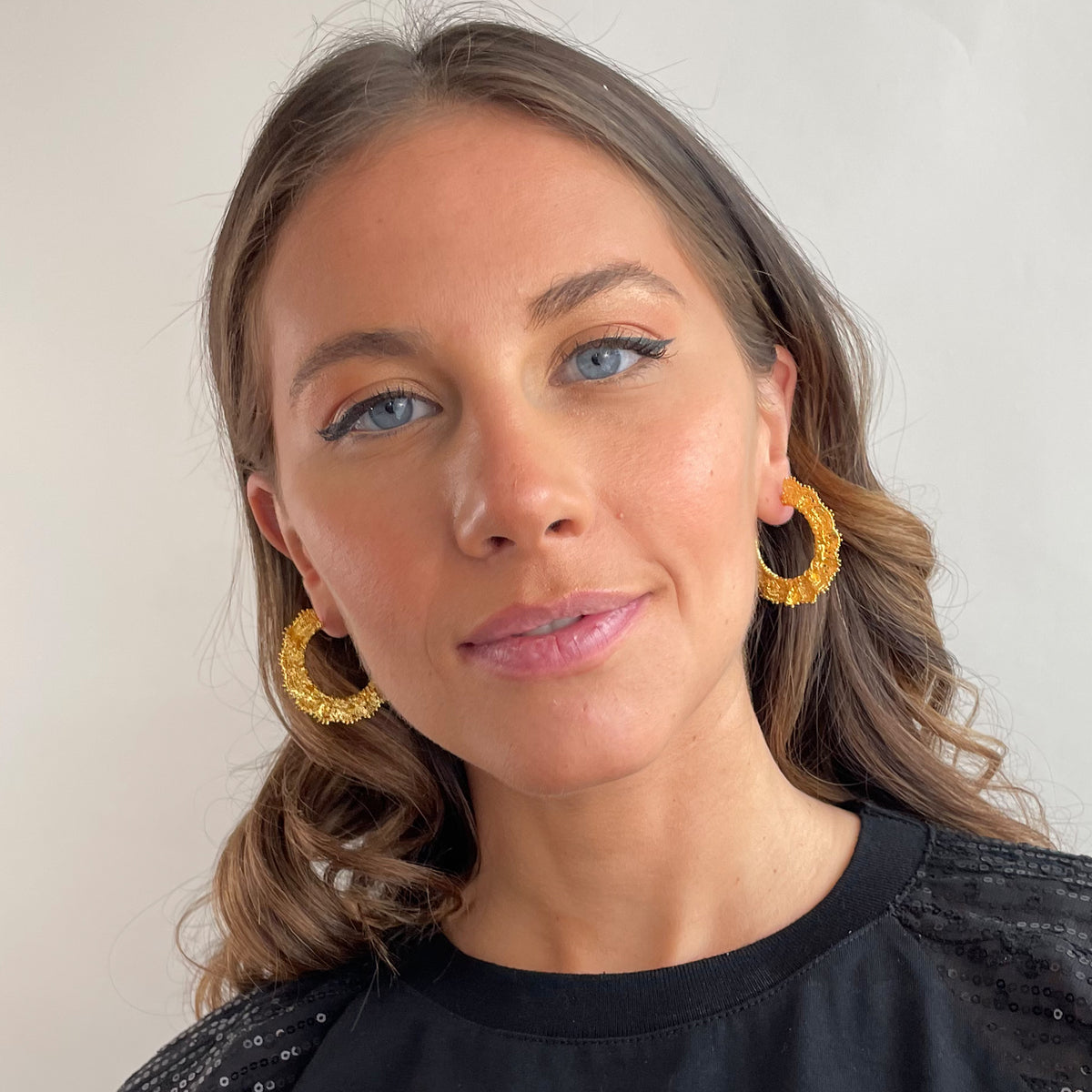 Jeanne lace hoop earrings small in 24k gold on a model.