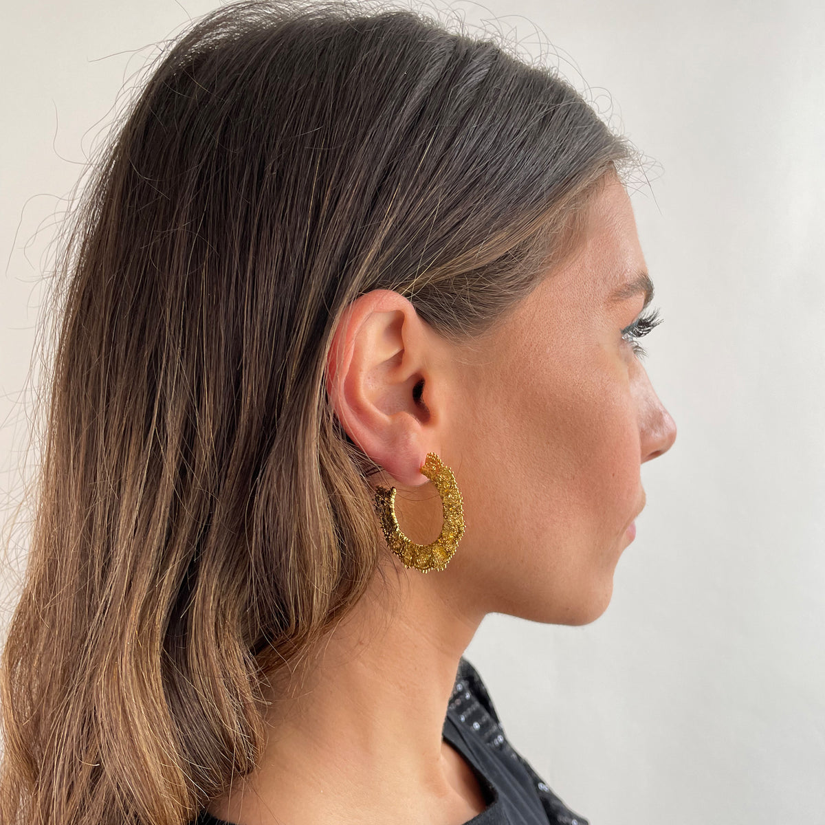 Jeanne lace hoop earrings small in 24k gold on a model.
