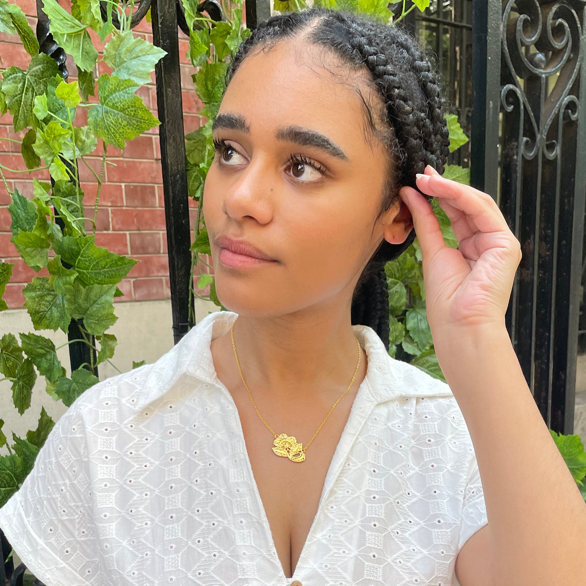 Fine lace rose necklace in 24k gold on model.