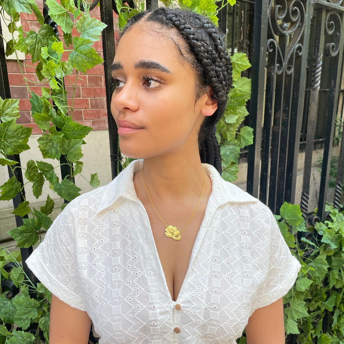 Fine lace rose necklace in 24k gold on model.