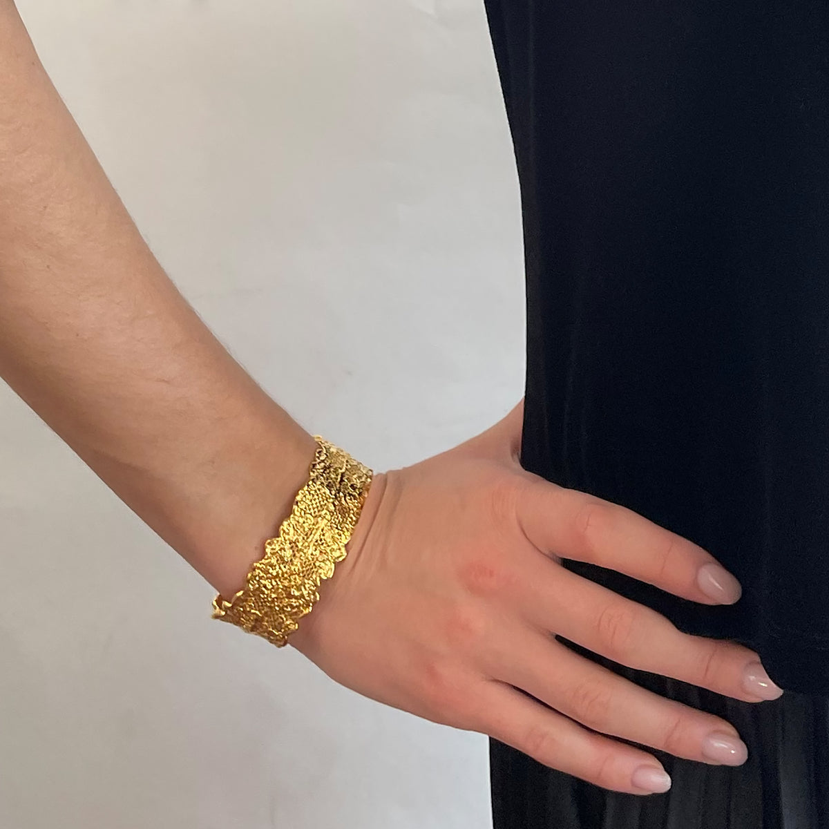 Marlene double scalloped lace bracelet in 24k gold worn by a model.