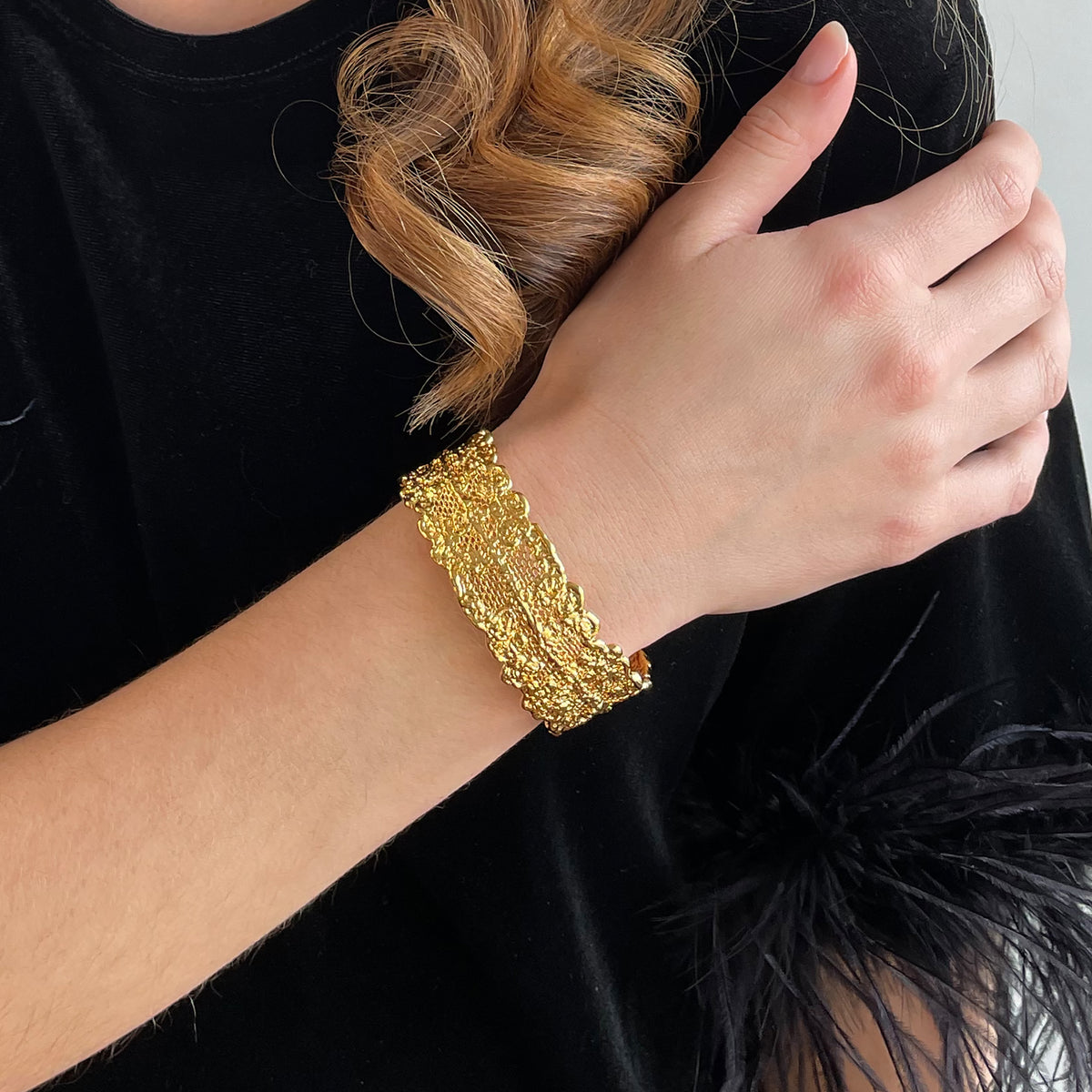 Marlene double scalloped lace bracelet in 24k gold worn by a model.