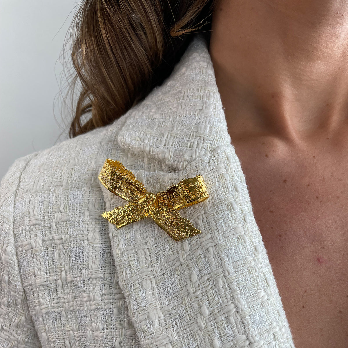 Bow Lace Brooch in 24k gold on a model.
