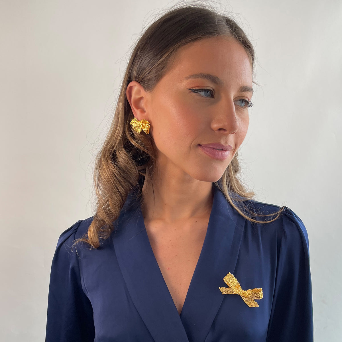 Bow Lace Brooch in 24k gold on a model.