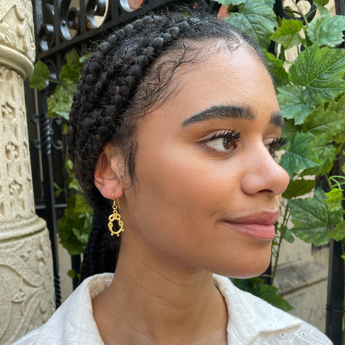 Irish tatted lace earrings in 24k gold worn by model.