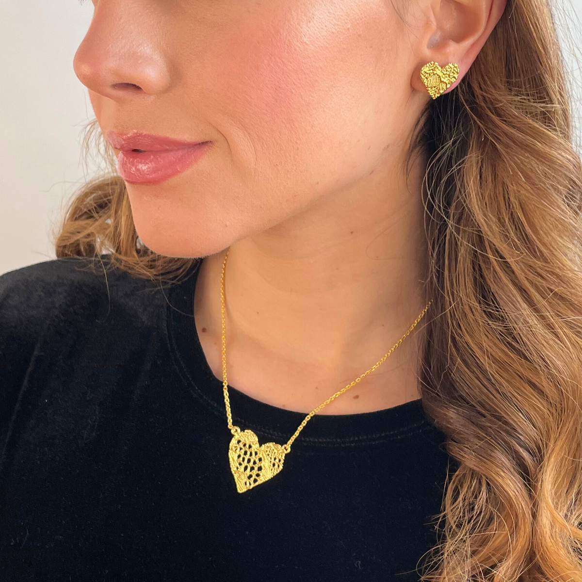 Remy lace heart necklace in 24k gold worn by a model.